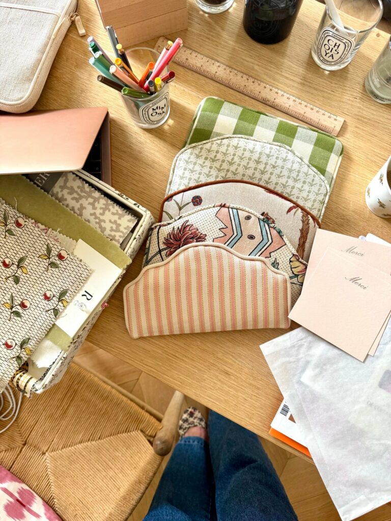 Miniatures de têtes de lit et échantillons de tissus sur le bureau de l’atelier