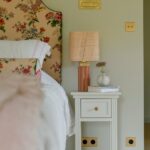 Chevet Percy blanc au pied d’une tête de lit Georgie fleurie