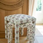 Deux tabourets Mary en tissus fleuris devant une boiserie