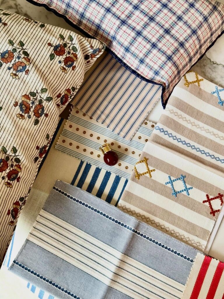 Sélection de tissus rayés, fleuris et à carreaux sur la table de l’atelier